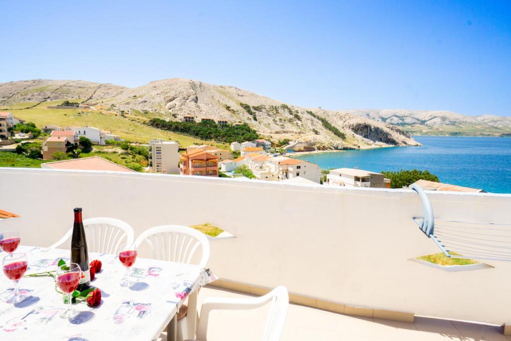 een tafel en stoelen op een balkon met uitzicht op de oceaan bij Magdalena with mountain and seaview in Metajna