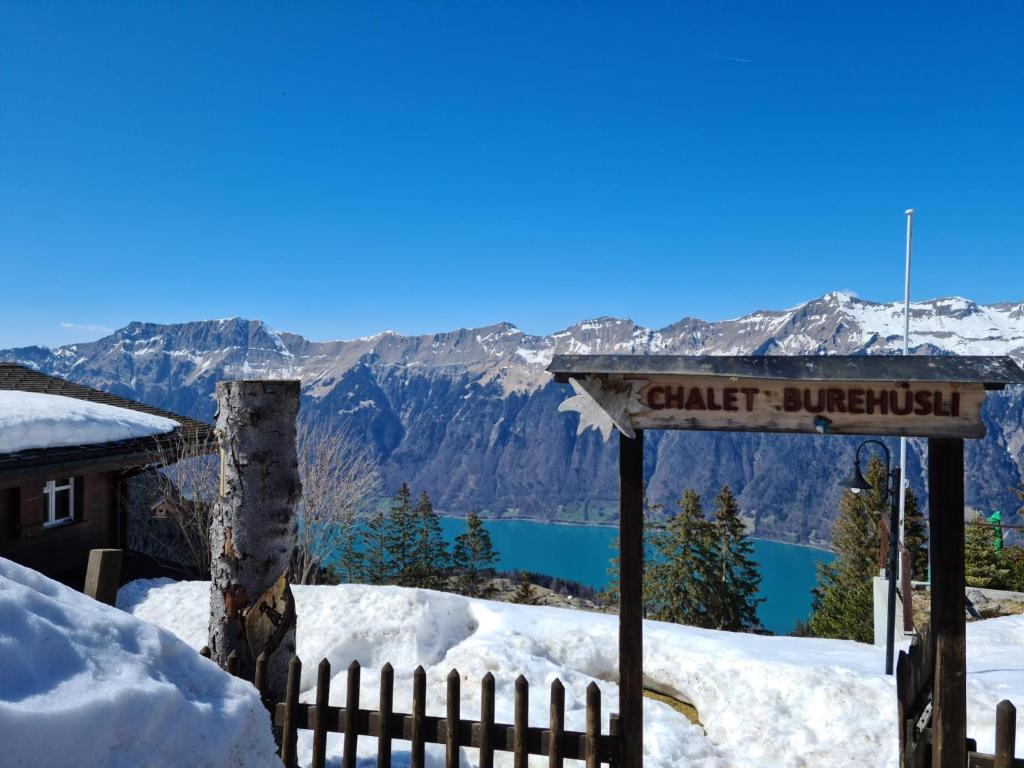 a sign in the snow with a view of a lake at Burehüsli Axalp in Axalp