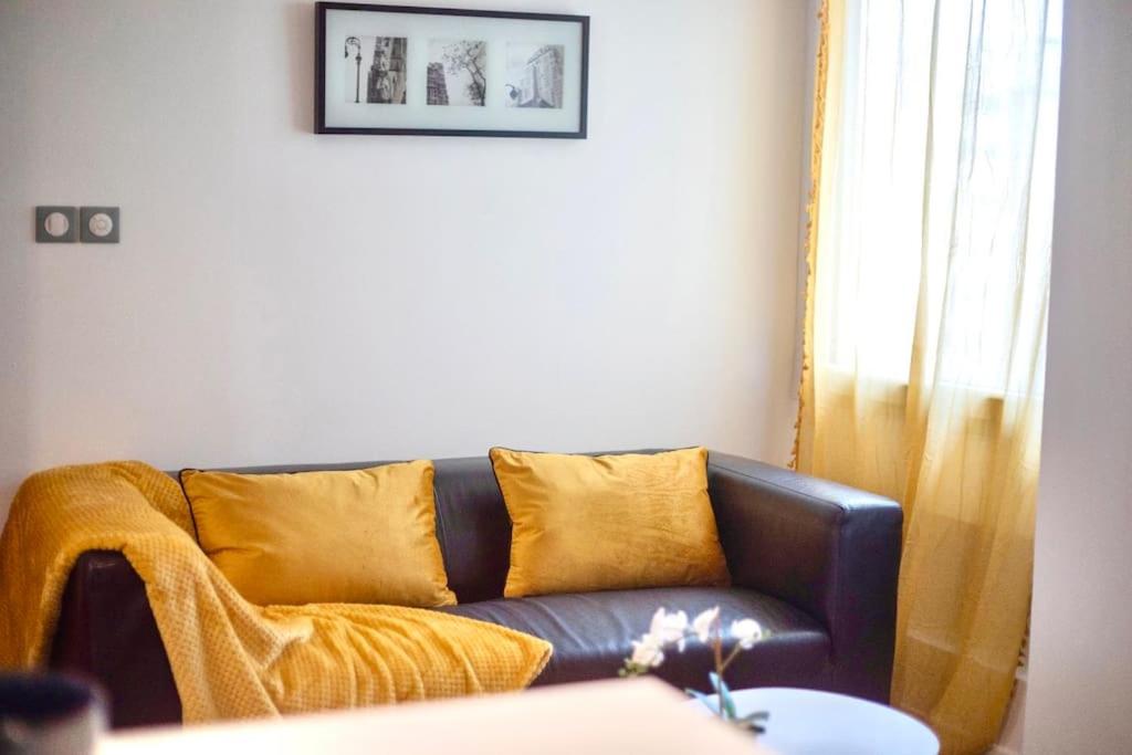 een bank met gele kussens in de woonkamer bij T2 Cosy & moderne avec Parking Privé Gratuit à Villeurbanne in Villeurbanne