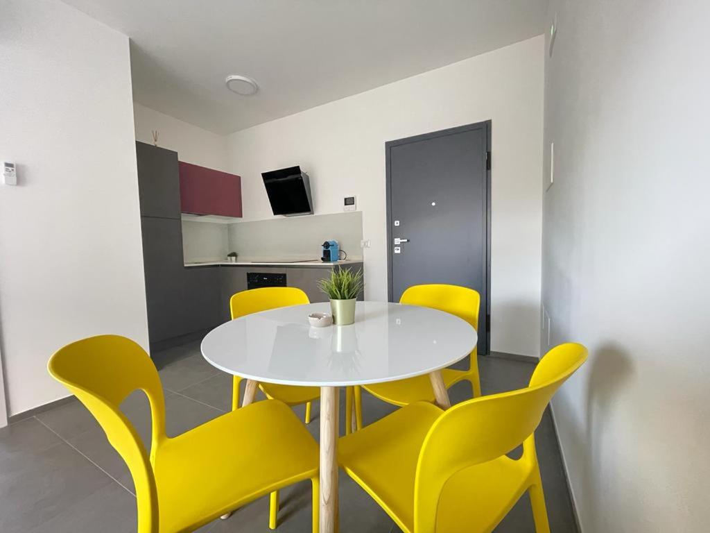 une salle à manger avec une table blanche et des chaises jaunes dans l'établissement Nuovo a 40 passi dal mare. A casa di “Bicca”, à Tortoreto Lido