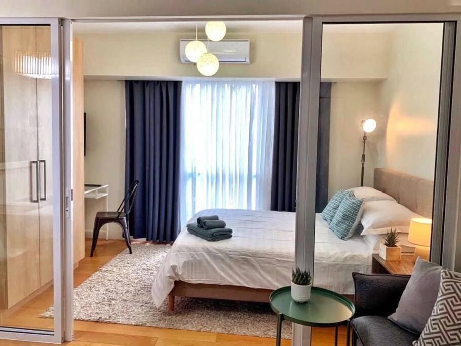 - une chambre avec un lit et un salon dans l'établissement A2J 1BR Luxury River View Suite Near Rockwell Mall, à Manille