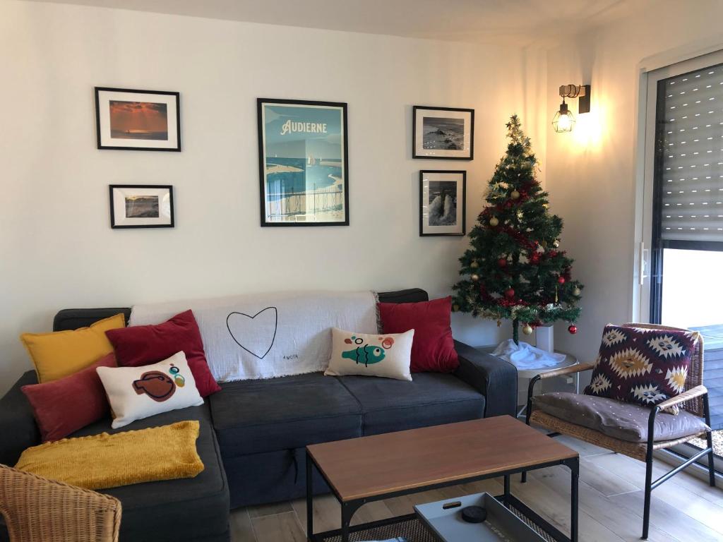 a living room with a christmas tree and a couch at kercady 1 in Audierne