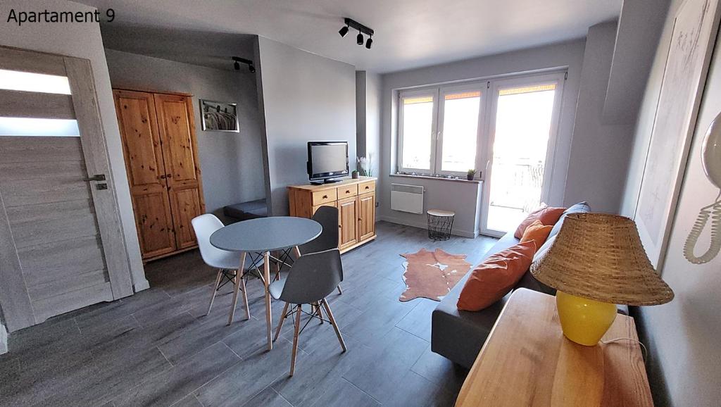 a living room with a couch and a table at Apartament Rybacka 84/9 in Krynica Morska - Piaski