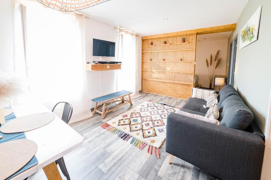 sala de estar con sofá y mesa en Apt neuf / tout confort / 7 mn d'Auxerre / Netflix 
