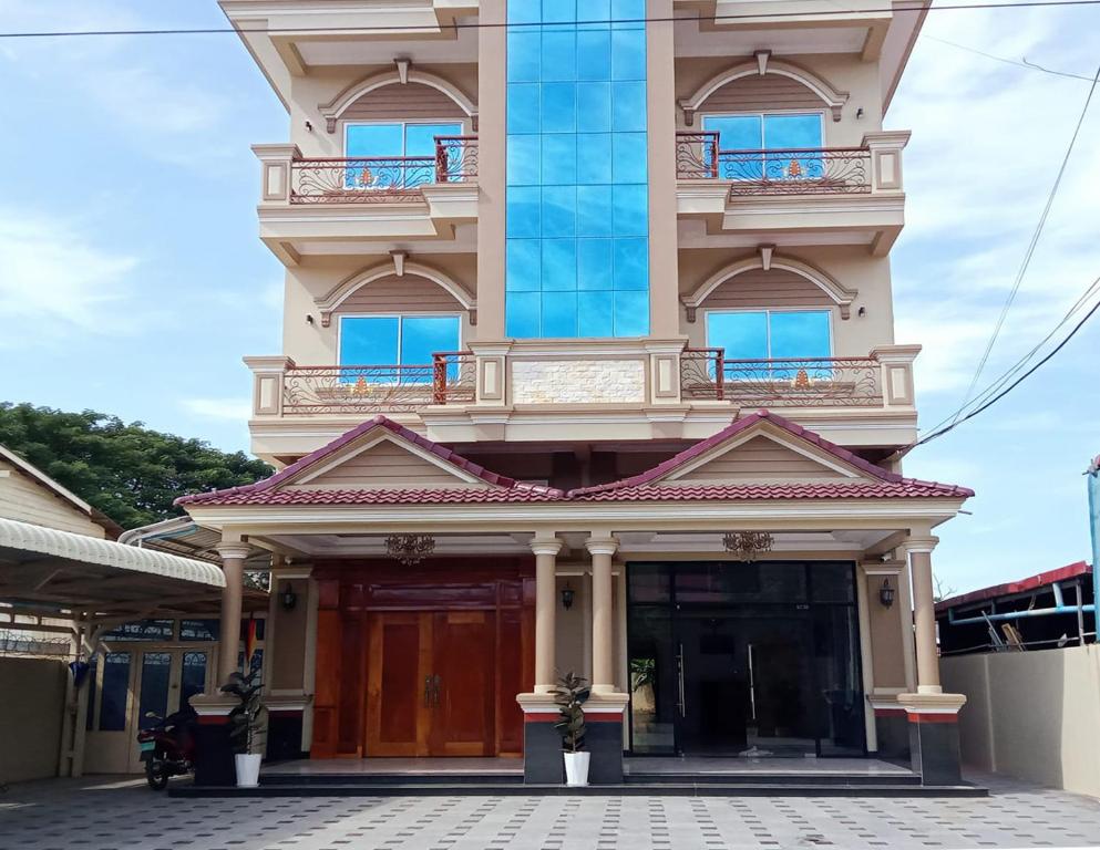 a tall building with a door and a balcony at Seagull Guesthouse Kampot in Kampot