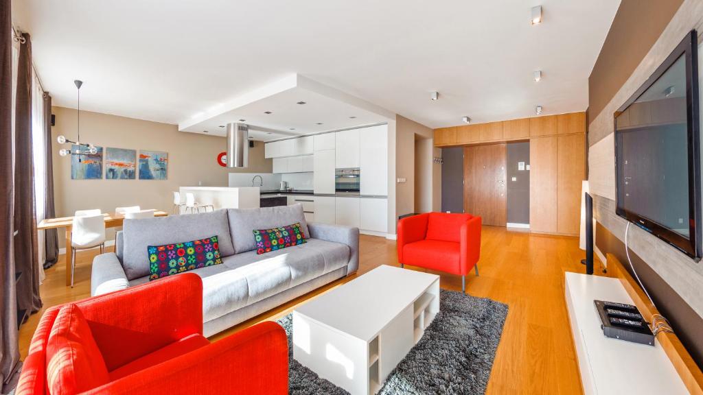 uma sala de estar com um sofá e cadeiras vermelhas em Apartamenty Sun & Snow Wczasowa Apartamenty Południowe em Ustka