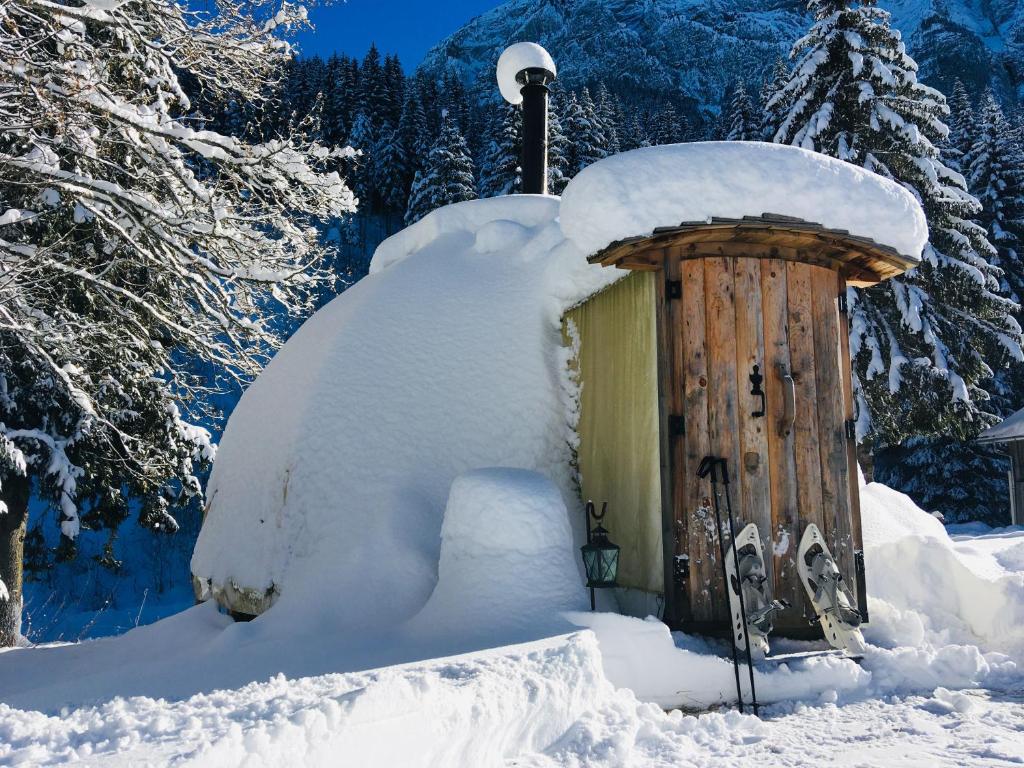 une cabine recouverte de neige avec un tas de neige autour de celle-ci dans l'établissement Altipik - Lodges Insolites, à Mont-Saxonnex