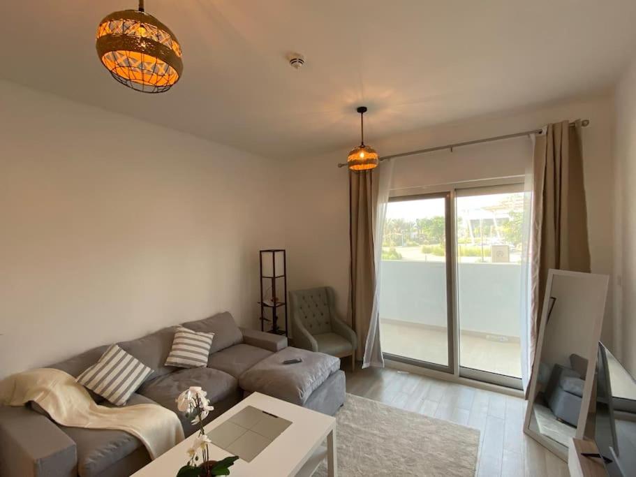 uma sala de estar com um sofá e uma mesa em Home-like modern 1 bedroom apartment SeaWorld view em Abu Dhabi