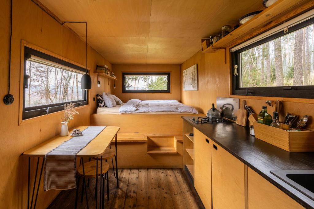 a tiny house with a kitchen and a bed at Včelíny Želiv in Želiv