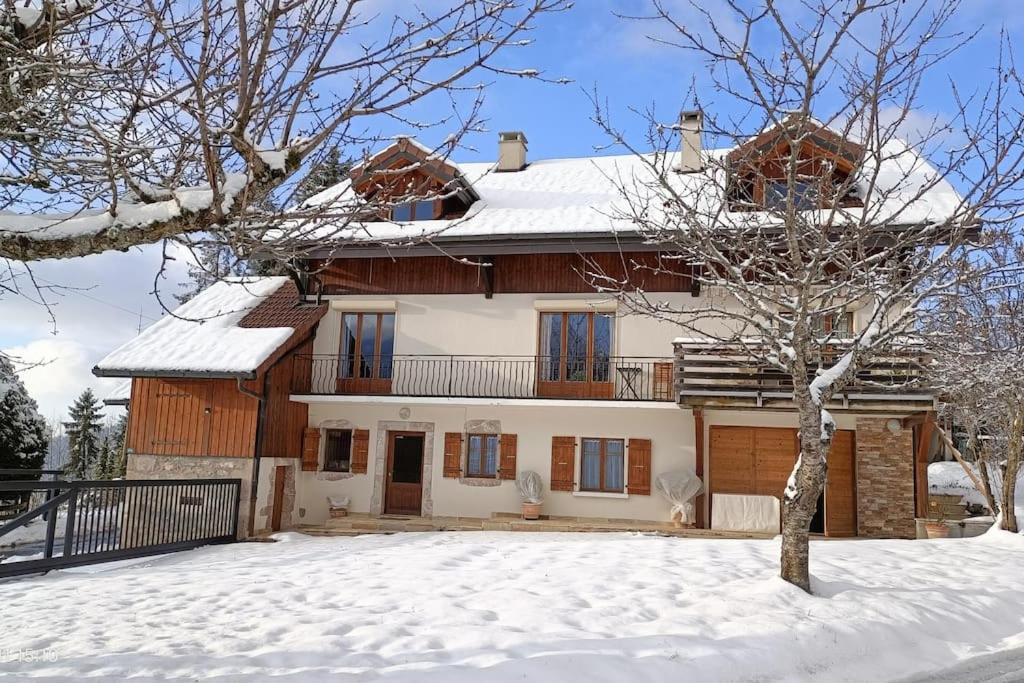 una casa con nieve en el suelo delante de ella en Gîte Cœur de Haute-Savoie en Viuz-en-Sallaz