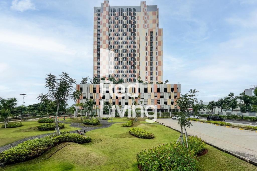 a tall building with a park in front of it at RedLiving Apartemen Sayana - Sentra Jaya in Bekasi