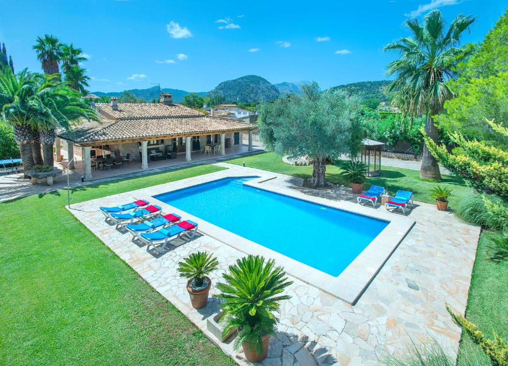 uma vista sobre uma piscina com cadeiras e uma casa em Owl Booking Villa Can Pou - Luxury Holidays in Royal Gardens em Pollença