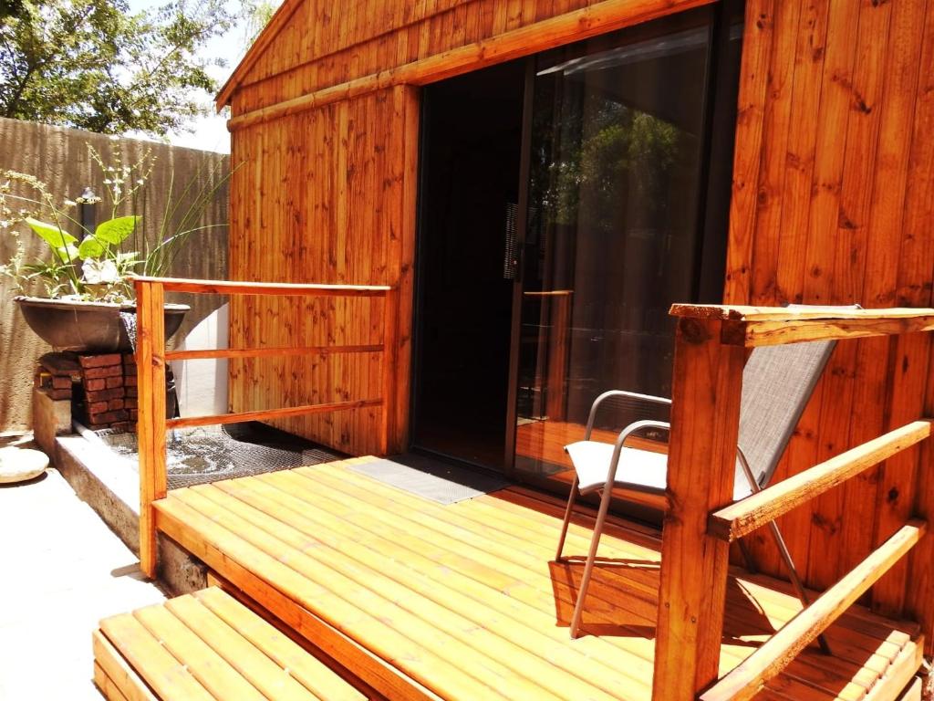 une terrasse en bois avec une chaise dans une cabine dans l'établissement ZUCH Accommodation at Pafuri Self Catering - Guest Cabin, à Polokwane