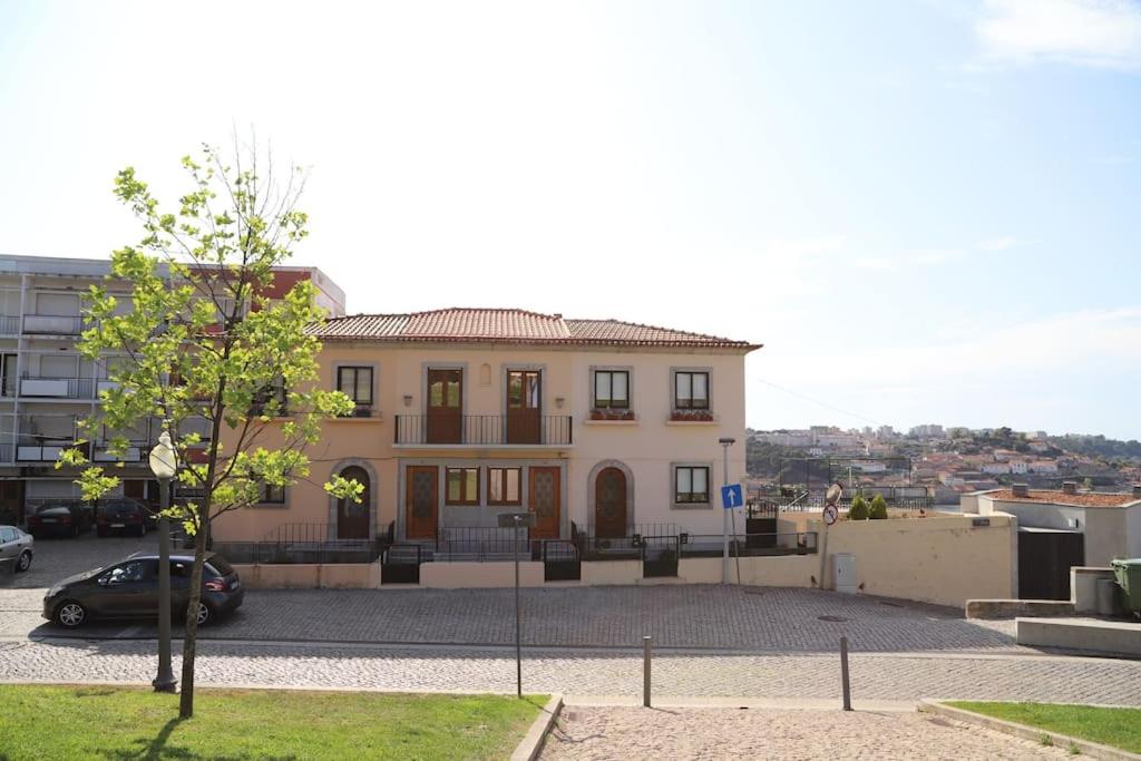 une grande maison avec une voiture garée devant elle dans l'établissement Casa do Pilar - D. Luís I, à Vila Nova de Gaia