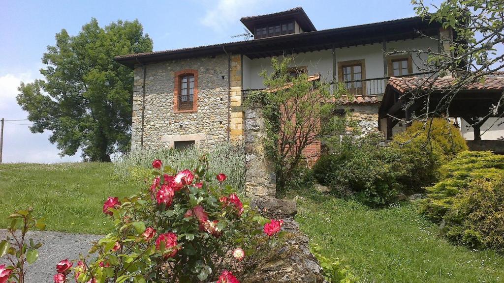 a stone house with flowers in front of it at Finca el Palacio in Torín