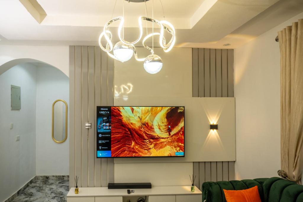 uma sala de estar com uma televisão de ecrã plano na parede em Live By The Water 2-Bed-Apt With FAST Wi-Fi And Secured em Amuwo