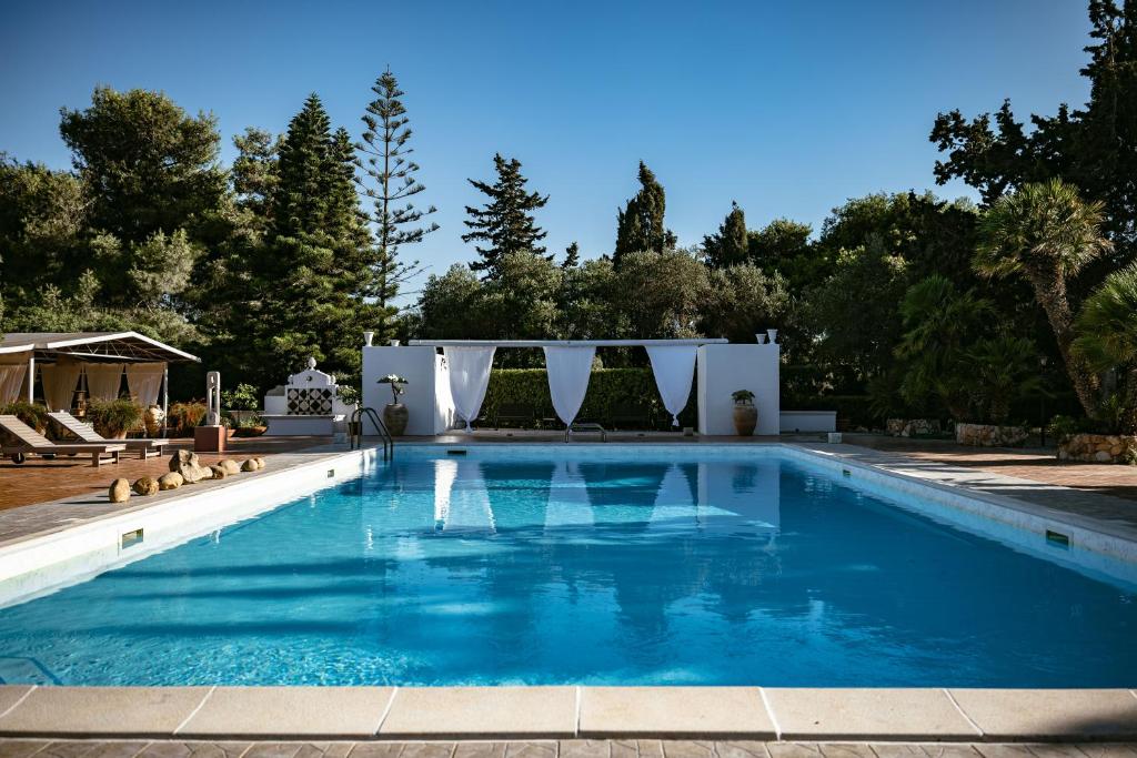 a swimming pool in a backyard with blue water at Giardino dell'impossibile di Antonino Campo in Favignana