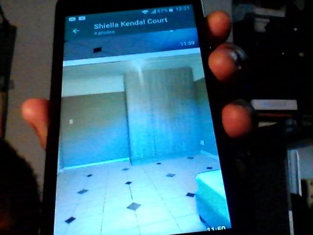 a person holding a cell phone up to a room at no4 Kendal court in Cape Town