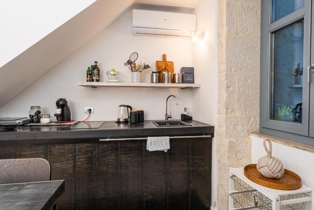 - une cuisine avec un évier et un comptoir dans l'établissement Vittorio Veneto by Bed&Bros, à Syracuse