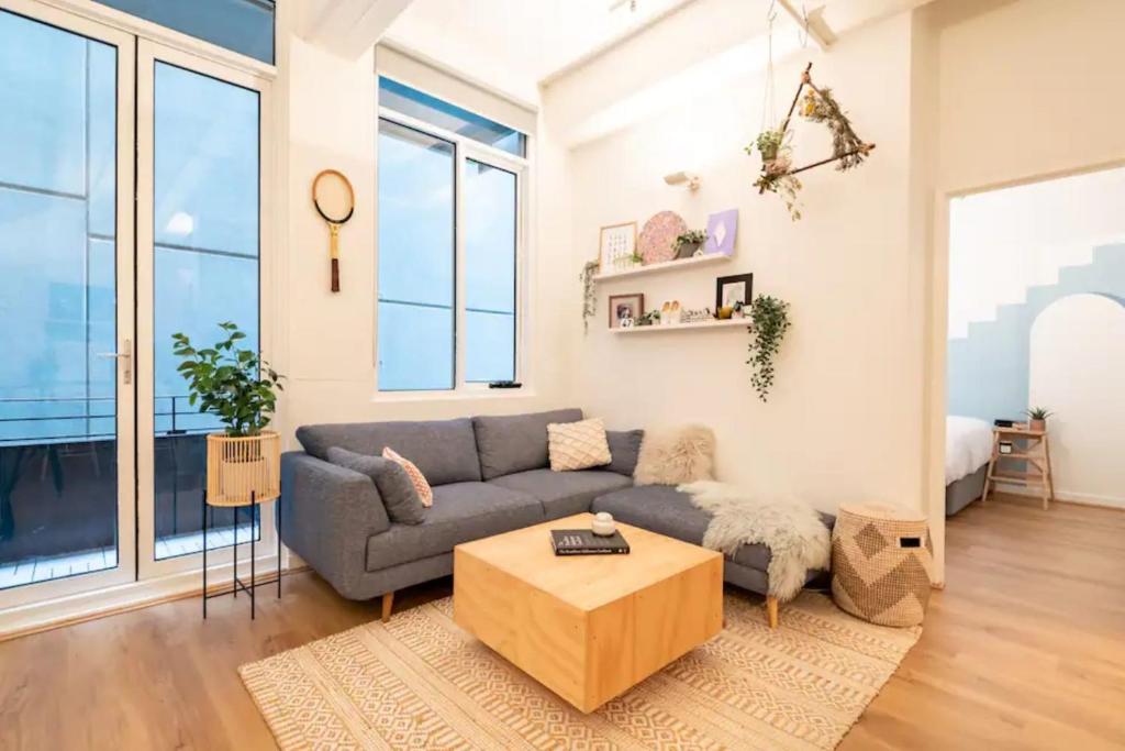 een woonkamer met een bank en een tafel bij Beautiful 1 Bedroom Apartment next to Southern Cross Station in Melbourne