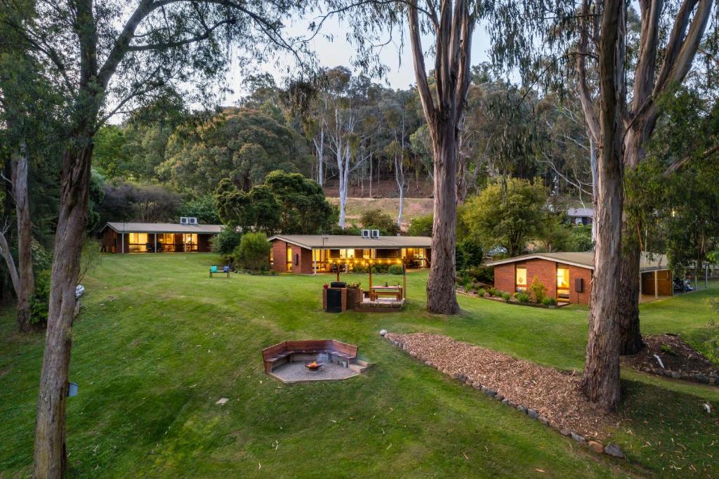 a house in the middle of a yard with trees at Kiewa Country Cottages in Mount Beauty