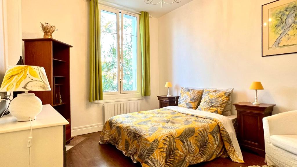 sypialnia z łóżkiem i oknem w obiekcie Petit Appartement dans une maison w Bajonnie