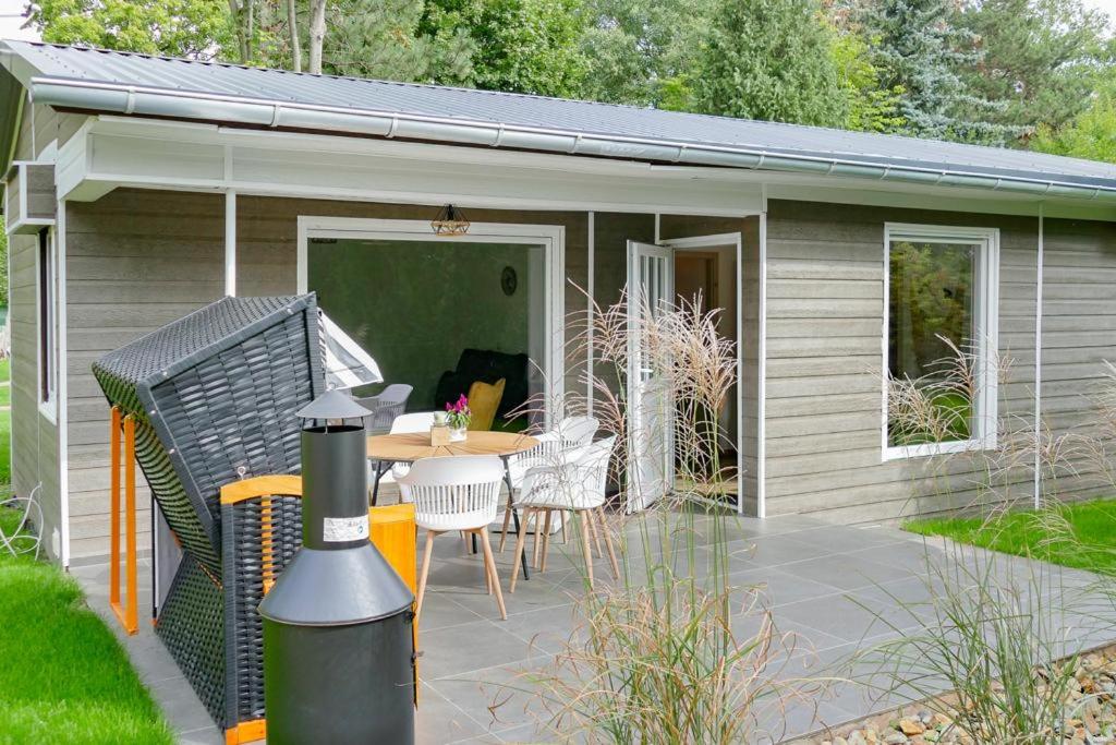 a small shed with a table and chairs and a patio at Ferienhäuser Kiebitzsee in Falkenberg