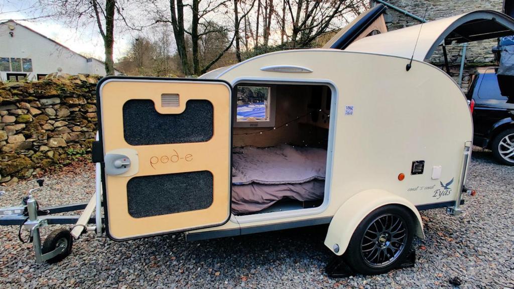 a small white trailer with its door open at Wallace Teardrop Caravan for Hire from ElectricExplorers in Hawkshead