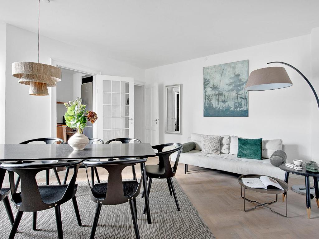 sala de estar con mesa, sillas y sofá en Sanders Stage - Charming Three-Bedroom Apartment Near Nyhavn, en Copenhague