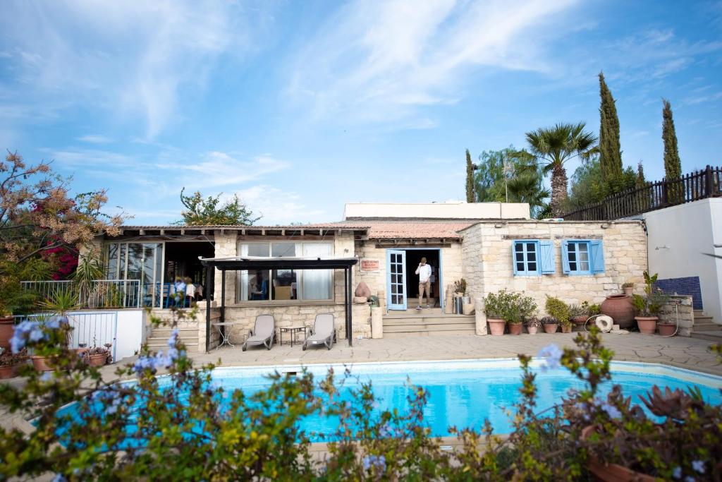 a house with a swimming pool in front of it at Cyprus Villages Hotel & Restaurant - Central Location - Bed & Breakfast - With Access To Pool And Stunning Views in Tochni