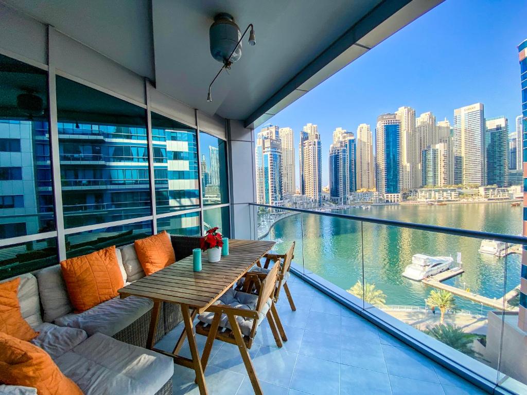 een balkon met een tafel en uitzicht op de stad bij Exquisite Spacious Deluxe one bedroom Apartment, Stunning Marina Views, Full Kitchen High-Speed Internet, Dubai Marina Gem, By "La Buena Vida Holiday Homes" in Dubai