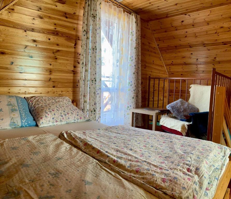 a bedroom with a bed in a wooden cabin at Domki wczasowe u Ewy in Chłopy