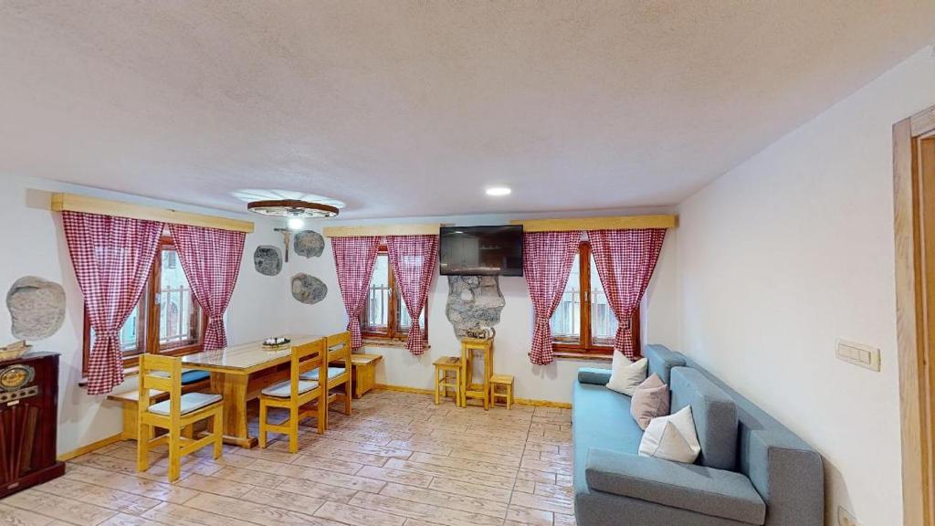 un soggiorno con divano blu e tavolo di hiša Margit, Rateče 150 a Rateče