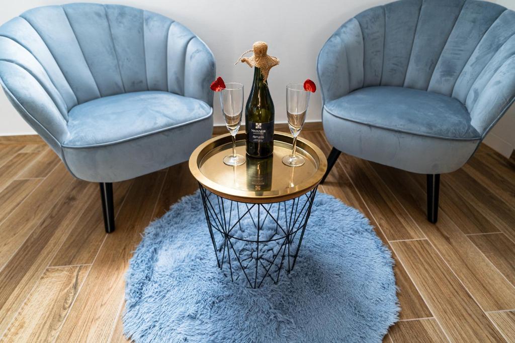 due sedie blu e un tavolo con una bottiglia di vino di Penzion Monner a Mikulov