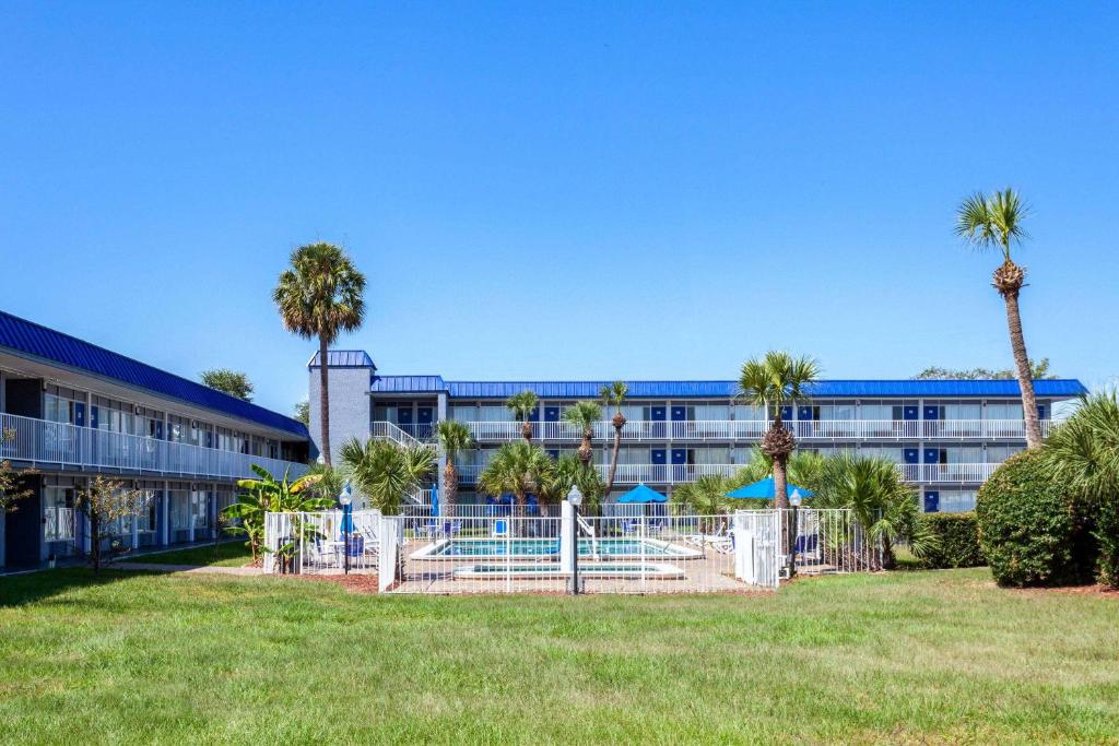 a building with palm trees in front of a park at Days Inn by Wyndham Orlando Downtown in Orlando