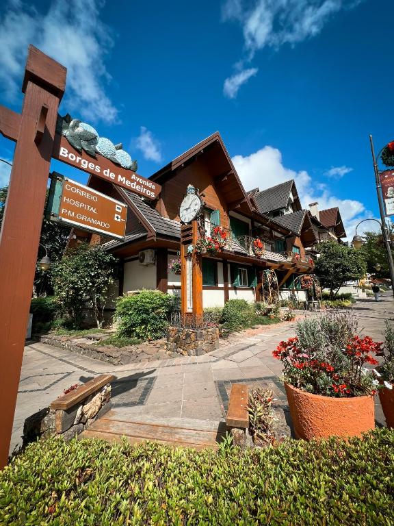 a building with a clock in front of it at Hotel Vovó Carolina in Gramado