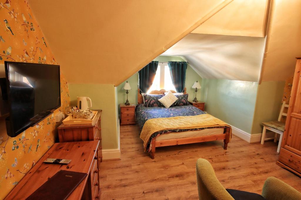 a bedroom with a bed and a tv in a room at Beaches BandB in Paignton