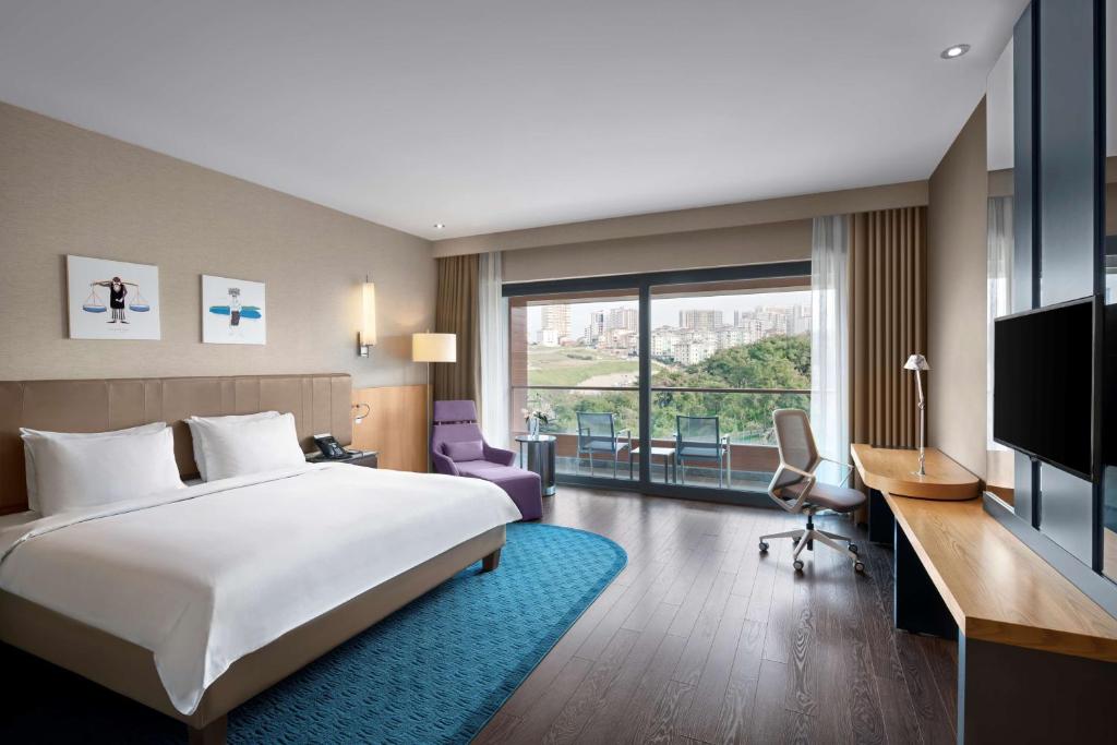 a hotel room with a bed and a desk and a tv at Radisson Blu Hotel & Spa, Istanbul Tuzla in Istanbul