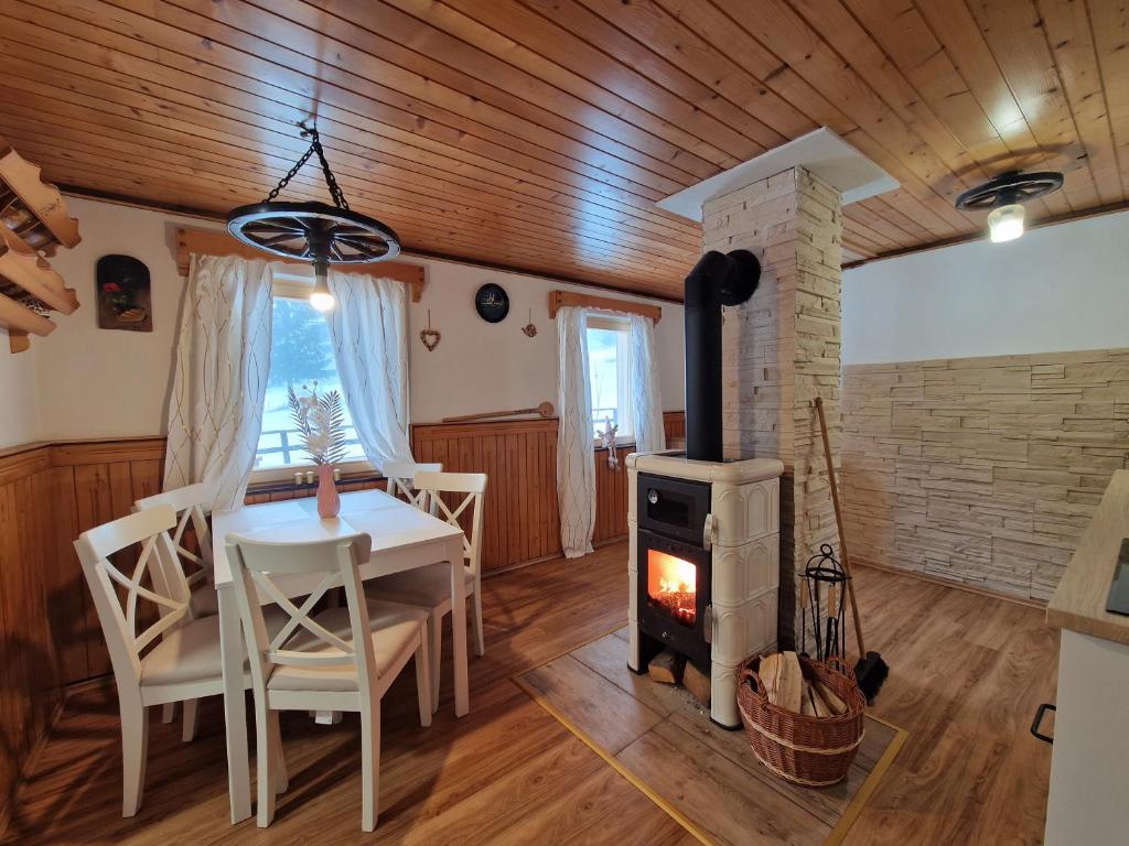 ein Wohnzimmer mit einem Tisch und einem Holzofen in der Unterkunft Triglav Cottage in Bohinj