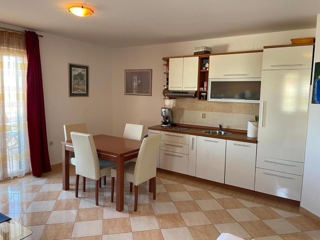 a kitchen with a table and chairs and a kitchen with white cabinets at Apartment Aurelia in Bol