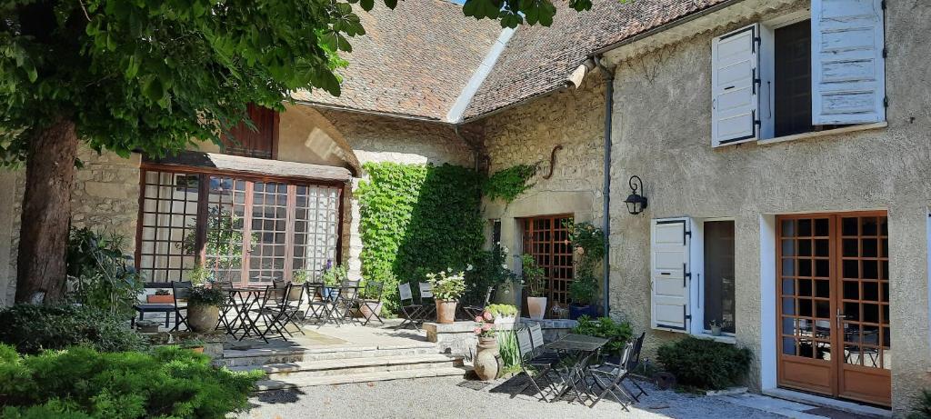 a building with tables and chairs in a courtyard at Les Vagabonds du Mont in Chichilianne