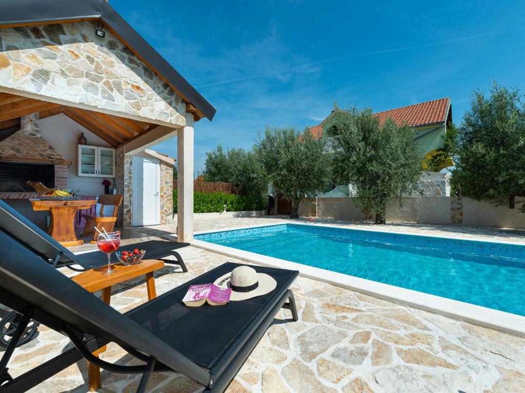 een villa met een zwembad en een patio bij Holiday home Antonia with pool in Galovac
