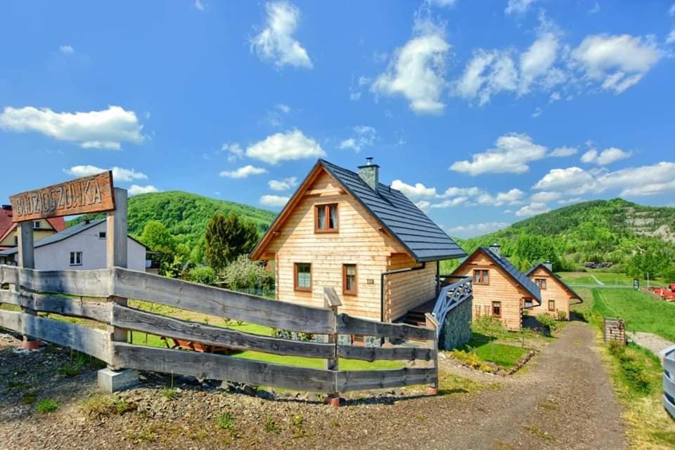 una granja con una valla y una casa en Domki całoroczne DOMKOWSTWO en Bóbrka