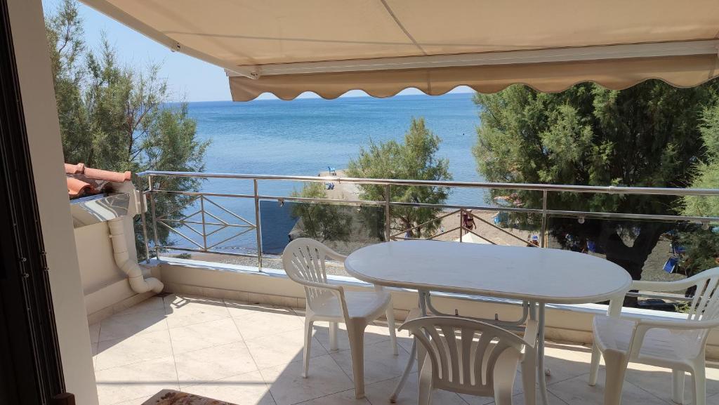 una mesa y sillas en un balcón con vistas al océano en Lesvos Tavari bay en Tavari