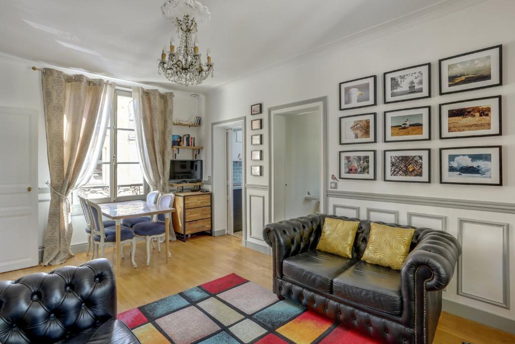 a living room with a couch and a table at Aux Loges de L'orangerie in Versailles