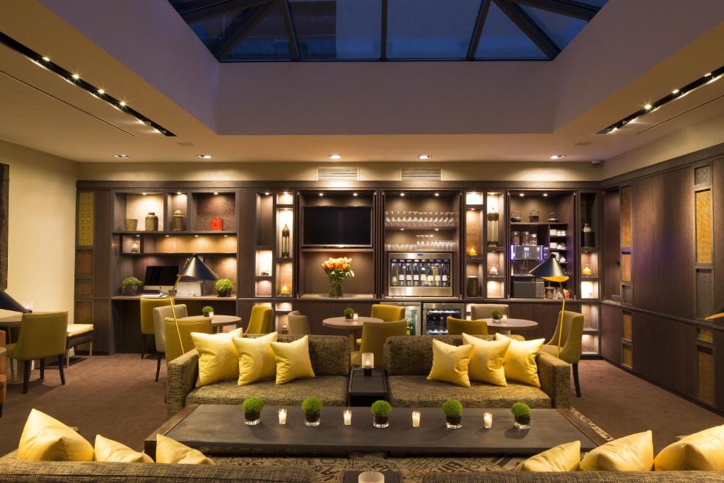 a hotel lobby with yellow furniture and a bar at Hotel Villa Saxe Eiffel in Paris