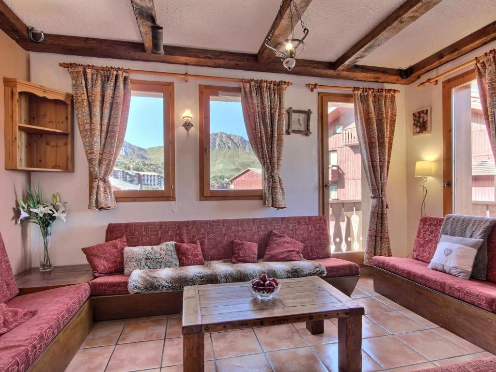 un salon avec des canapés rouges et une table dans l'établissement Chalet pour 11 personnes au pied des pistes à La Plagne, avec garage et balcons - FR-1-455-202, à La Plagne Tarentaise