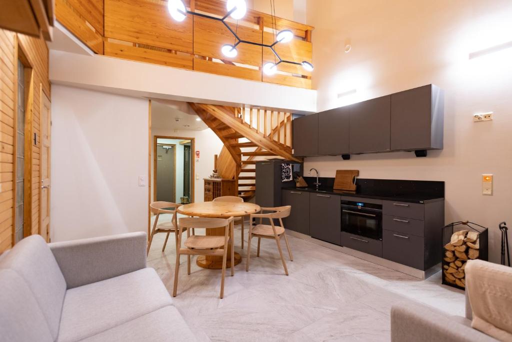 a kitchen with a table and a dining room at HolySuites 1 "Roggenecke" - Cosy Slope Side Apartment with Scenic Views in Pyhä Ski Resort in Pyhätunturi