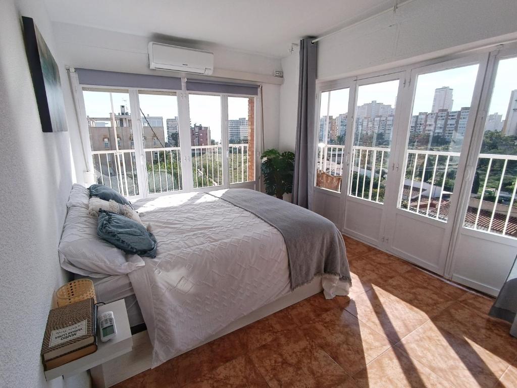 una camera con letto e ampie finestre di California Suite - All-day Sunny 2-Bedroom Apartment a El Campello