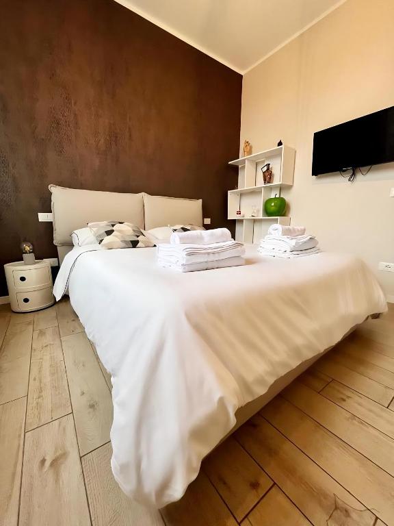 a large white bed in a room with a tv at Casa Nanà in Florence